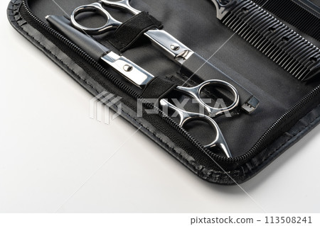 Hairdressing scissors with leather case on white background 113508241
