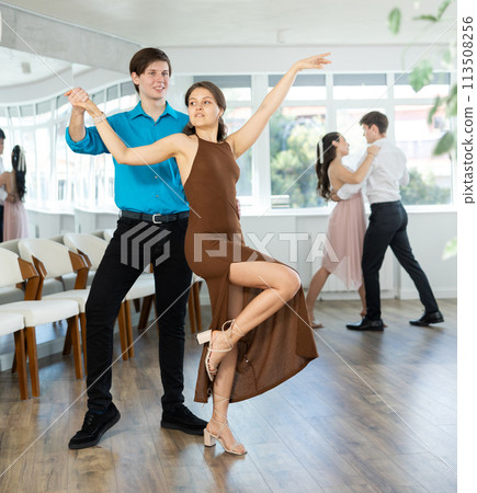 Guy enjoying impassioned merengue with female partner in dance class Guy enjoying impassioned merengue with female partner in dance class 113508256