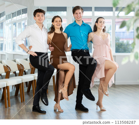 Guys and girls company in evening costumes perform movement of classic folk Irish dance 113508287