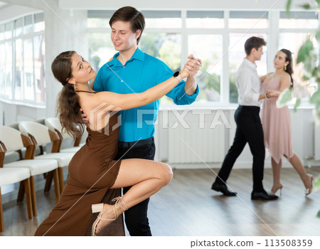 Guy rehearsing elegant tango with young female partner Guy rehearsing elegant tango with young female partner 113508359