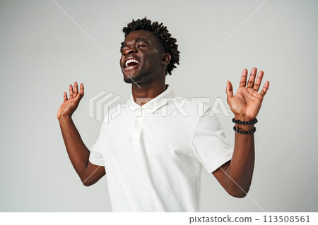 Young African Man Standing With Hands Raised Young African Man Standing With Hands Raised 113508561