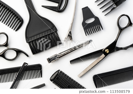 Black hairdressing tools and various hairbrushes on white background Black hairdressing tools and various hairbrushes on white background 113508579