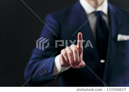 The hand of a businessman pointing at something on a black background 113508637