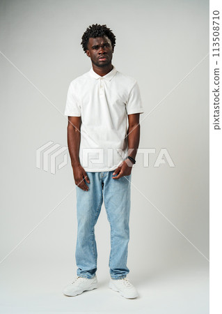 Young African American Man in White Shirt Expressing Confusion in Studio Young African American Man in White Shirt Expressing Confusion in Studio 113508710