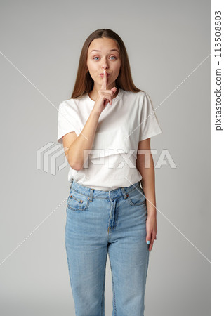 Young pretty woman saying hush be quiet hand sign on gray background Young pretty woman saying hush be quiet hand sign on gray background 113508803