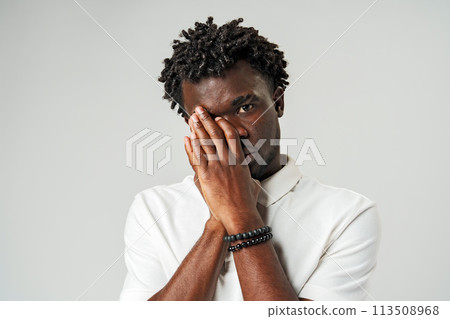 Young African Man Clutching His Face in Distress 113508968