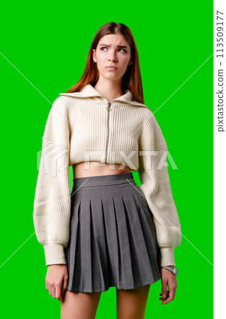 Woman in Skirt and Sweater Standing Against Green Background 113509177