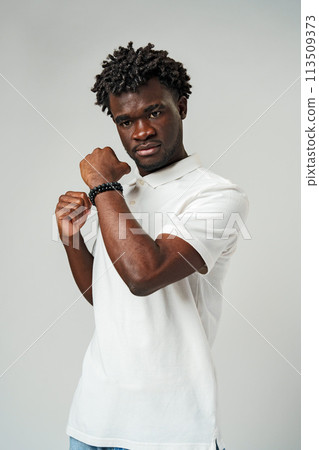 A man is standing and posing for a picture, with his fist raised in the air. A man is standing and posing for a picture, with his fist raised in the air. 113509373