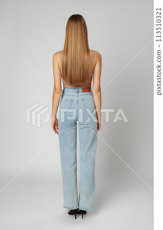 Back view full length photo of young woman with long hair on gray background 113510321