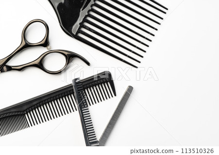 Black hairdressing tools and various hairbrushes on white background 113510326