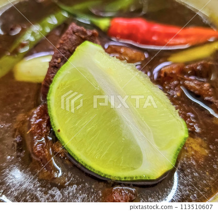 Rawon or Indonesian black beef soup, black color are from indonesian nut called kluwek. Served with lime, chili paste, salted egg, and tempe cracker. Perfect for recipe, article, or any cooking Rawon or Indonesian black beef soup, black color are from indonesian nut called kluwek. Served with lime, chili paste, salted egg, and tempe cracker. Perfect for recipe, article, or any cooking 113510607