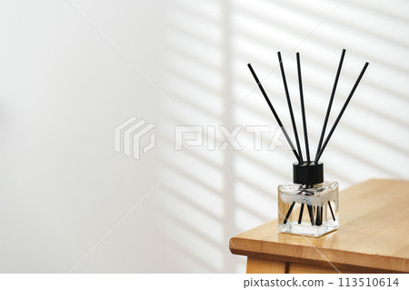 Modern Reed Diffuser on Wooden Table in Minimalist Interior During Daytime Modern Reed Diffuser on Wooden Table in Minimalist Interior During Daytime 113510614