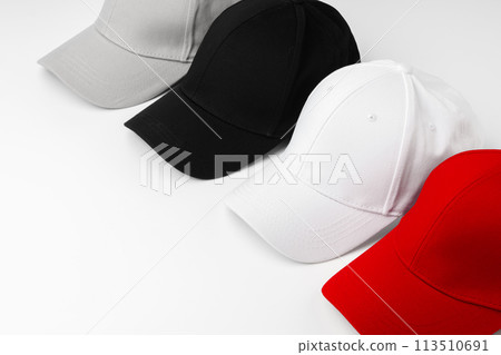 Lineup of Four Blank Baseball Caps in Red, White, and Black on a White Background 113510691