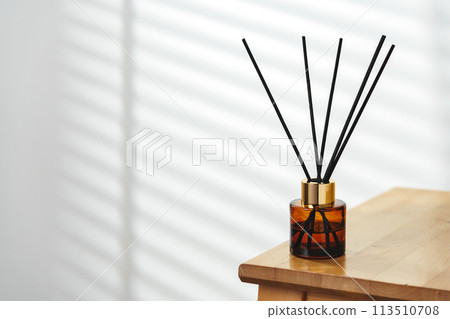 Elegant Reed Diffusers on Wooden Surface With Soft Background Light Elegant Reed Diffusers on Wooden Surface With Soft Background Light 113510708
