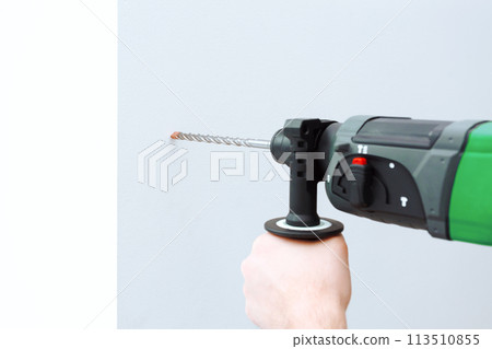 Use hammer drill to drill the wall Use hammer drill to drill the wall 113510855