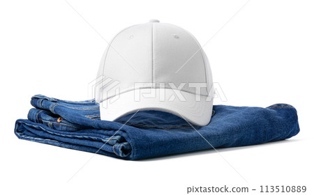 White Baseball Cap on Folded Blue Denim Jeans Against White Background 113510889