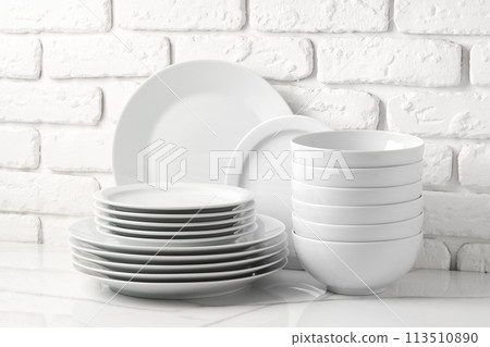 Set of dishes on table against brick wall background Set of dishes on table against brick wall background 113510890