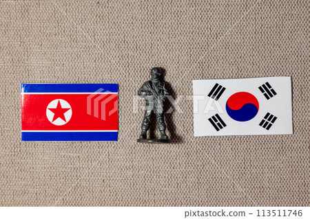 A soldier figurine on the background of the flags of North Korea and South Korea 113511746