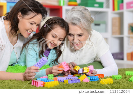 Portrait of cute girl playing with mom and grandma in cubes Portrait of cute girl playing with mom and grandma in cubes 113512064