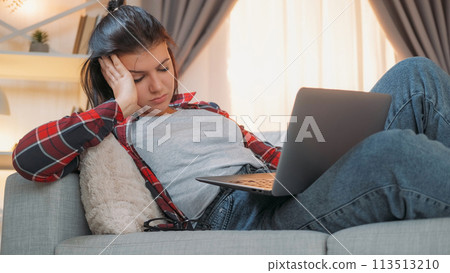 Sleepy woman. Internet addiction. Work fatigue. Overworked female freelancer sleeping with laptop sitting couch home room. Sleepy woman. Internet addiction. Work fatigue. Overworked female freelancer sleeping with laptop sitting couch home room. 113513210