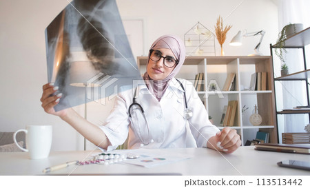 Online diagnosis. Physician consultation. Pneumonia treatment. Professional woman doctor examining lung x-ray medical expertise on internet video call at clinic. Online diagnosis. Physician consultation. Pneumonia treatment. Professional woman doctor examining lung x-ray medical expertise on internet video call at clinic. 113513442