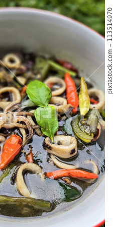 ndonesian home cooking menu, sauteed squid with black ink sauce with spicy seasoning called Tumis Cumi Hitam, including chili, ginger, and lime leaf 113514970