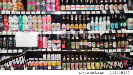 Abstract blurred image of alcohol store with trolley in department store. (Selective focused at shopping cart) 113516155