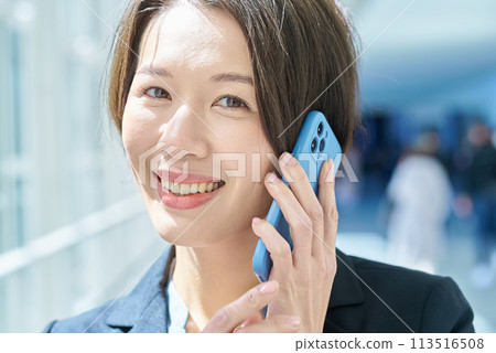 A woman talking on a smartphone 113516508