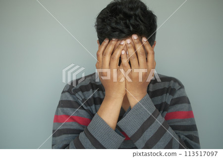 Close up of sad man covering face with hand. 113517097