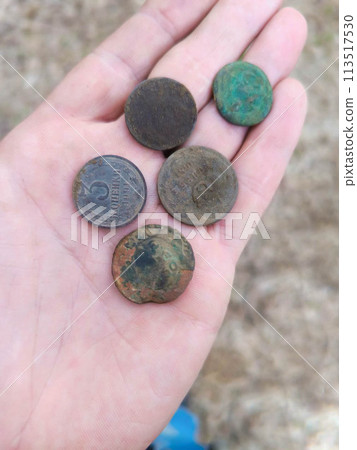 Hand holding vintage rusty dirty coins. Hand holding vintage rusty dirty coins. 113517530