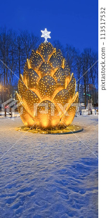 Christmas decoration on the city square is a huge glowing cone. Christmas decoration on the city square is a huge glowing cone. 113517532