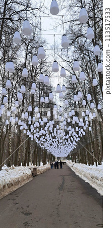 An alley in a city park with white hanging lanterns. An alley in a city park with white hanging lanterns. 113517533