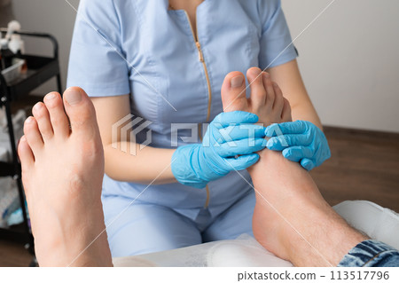 A man receiving a foot massage from a skilled masseur at the clinic 113517796