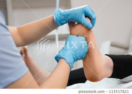 Masseur doing a professional foot massage in beauty salon. 113517821