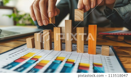 Expert hands place wooden blocks on a chart to illustrate the careful planning involved in successful capital management. Capital allocation 113518047