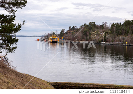 Small yellow Ro-Ro ferry goes near medieval Oscar Fredriksborgs fortification. Landmarks of Stockholm archipelag 113518424