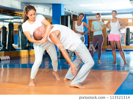 Young latina performing inverted headlock during self defence training 113521314