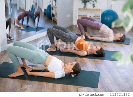 Group of women doing pilates in studio Group of women doing pilates in studio 113521322