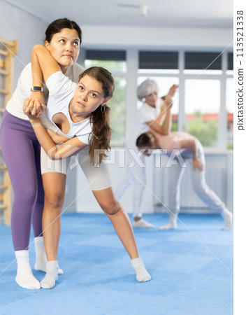 Two young women training self-defense techniques 113521338
