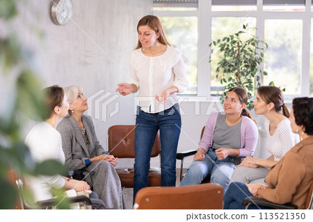 In classroom,girl stands next to colleagues and tells audience her vision of situation In classroom,girl stands next to colleagues and tells audience her vision of situation 113521350