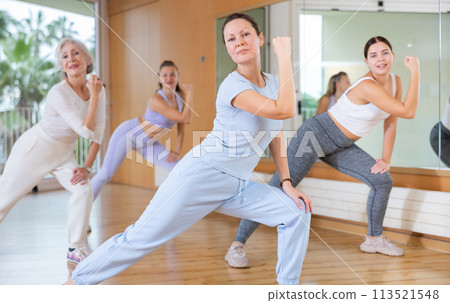 Active middle-aged woman practicing aerobic dance in training hall 113521548