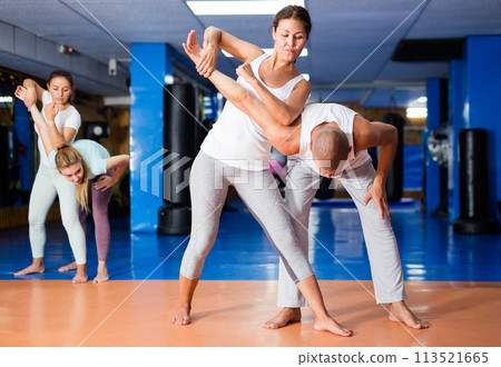 Asian woman practicing self-defence moves with her trainer 113521665