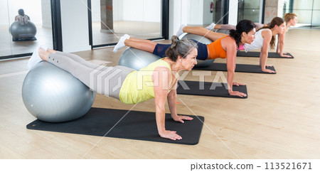 Women lying on gymnastic ball. Fitness workuot in gym Women lying on gymnastic ball. Fitness workuot in gym 113521671