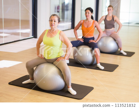 Four women sitting on swiss balls 113521832