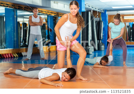 Girl performing hammerlock during self defence training in gym 113521835