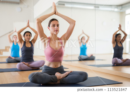 Sporty females practise yoga, meditation in lotus position 113521847