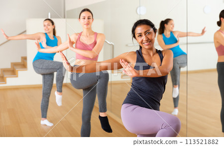 Cheerful hispanic woman practicing vigorous dance in group class 113521882