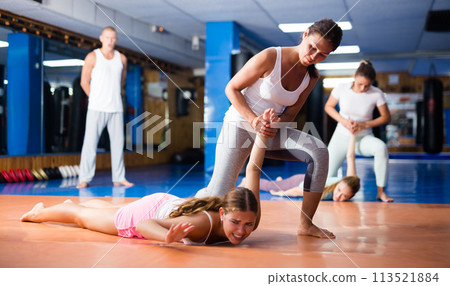 Asian woman practicing pronating wristlock on female opponent in sparring 113521884