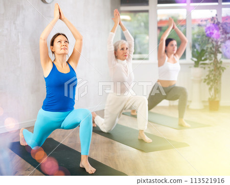 Active women practice the Anjanasana pose Active women practice the Anjanasana pose 113521916