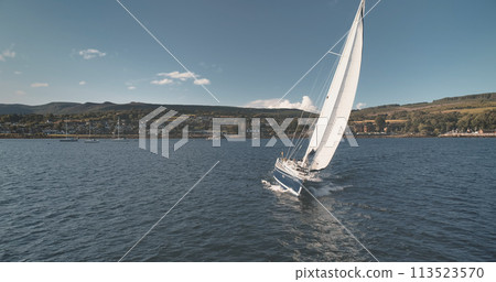 Yacht sailing at ocean bay aerial. Summer nobody nature seascape. Sailboat sun reflection. Port town 113523570